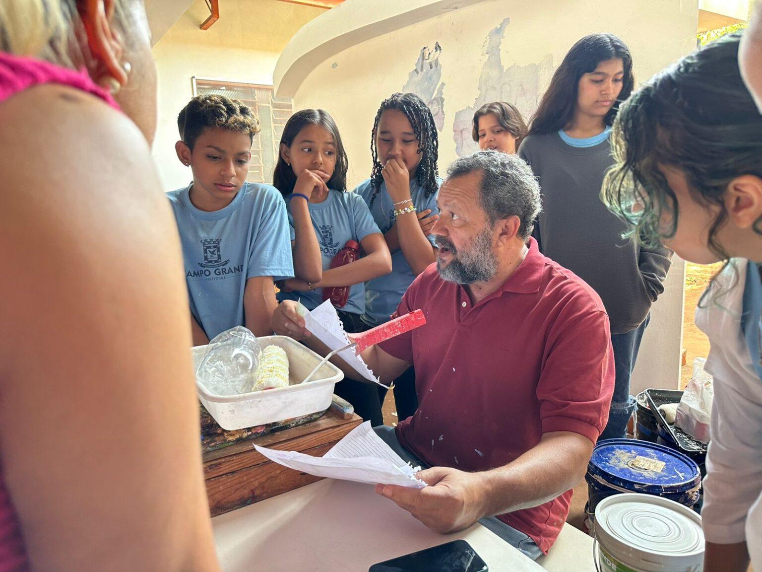 Para eternizar arte no muro da escola, alunos de escola da Reme convidam artista regional para compartilhar.