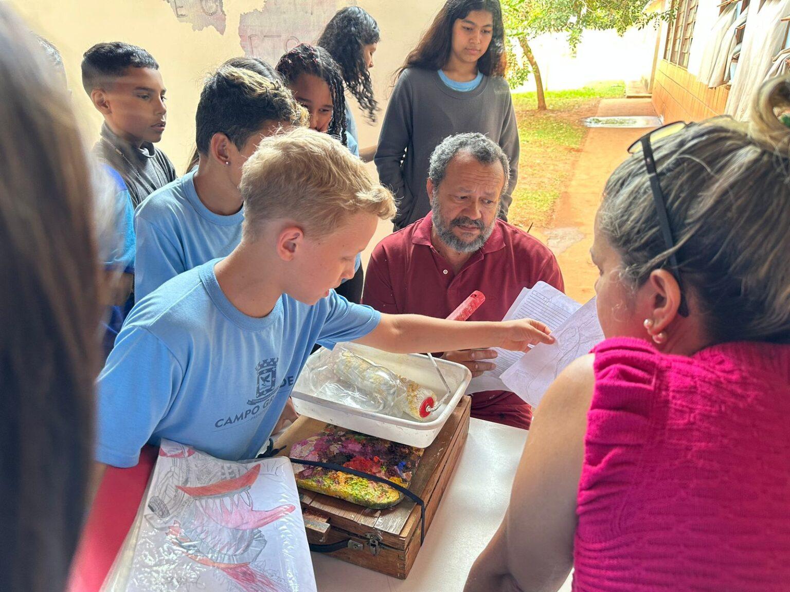Para eternizar arte no muro da escola, alunos de escola da Reme convidam artista regional para compartilhar.